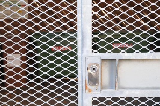 Roska-astioita jätekatoksen oven takaa katsottuna.