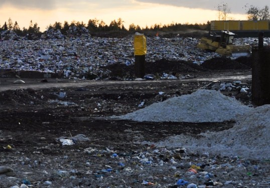 Muovikassikasoja ja puskutraktori kaatopaikalla.