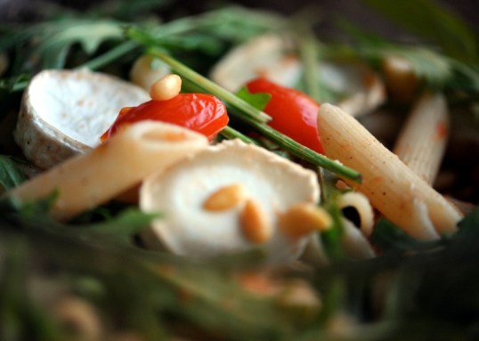 Pennepastaa, vuohenjuustoa, rucolaa, pienoisluumutomaatteja ja pinjansiemeniä.