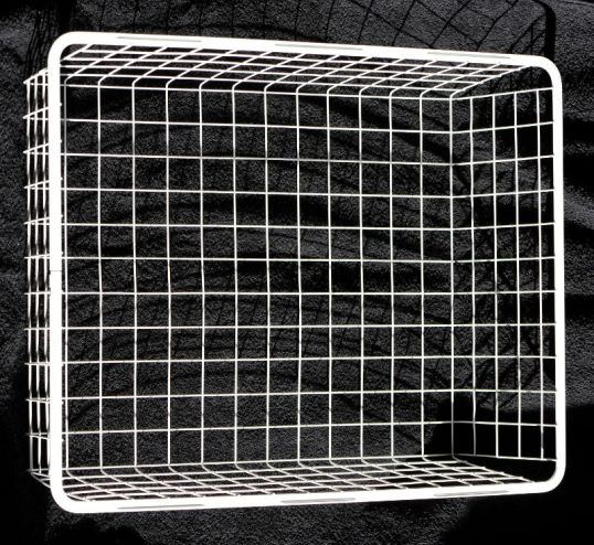 Valkoinen, metallinen ritiläkori, taustalla musta froteepyyhe.