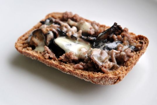 Ruispala, jonka päällä juustoa, jauhelihaa ja herkkusieniä.