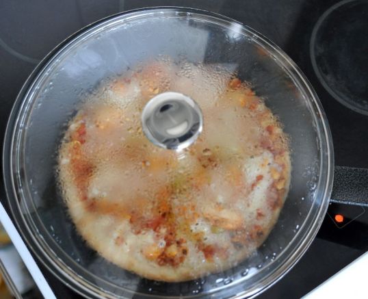 Pakastepitsa paistumassa paistinpannulla kannen alla.