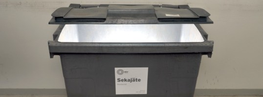 Sekajäteastia, jonka sisältä hohtaa valoa.