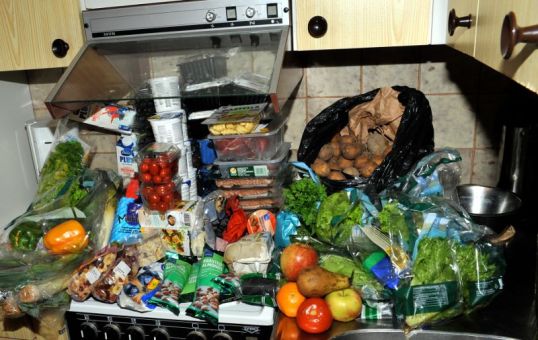 Iso kasa elintarvikkeita keittiössä lieden ja tiskipöydän päällä.