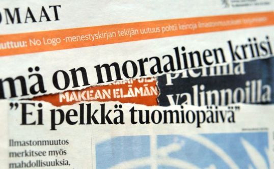 Leikkeitä Helsingin Sanomien ilmastonmuutosjutuista Valomerkki-kirjan päällä.