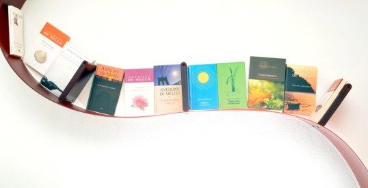 Anthony de Mellon suomenkieliset teokset rivissä punaisessa Bookworm-kirjahyllyssä.