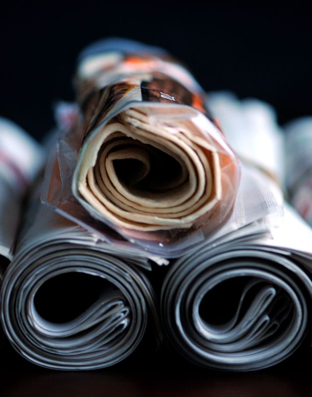 Tortilloja rullalle käärittyinä paketissaan rullattujen sanomalehtien päällä.