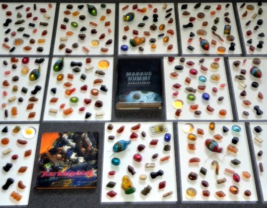 Karamelleja ja suklaita vierekkäisten A4-arkkien päällä sekä kaksi Karkkipäivä-kirjaa.