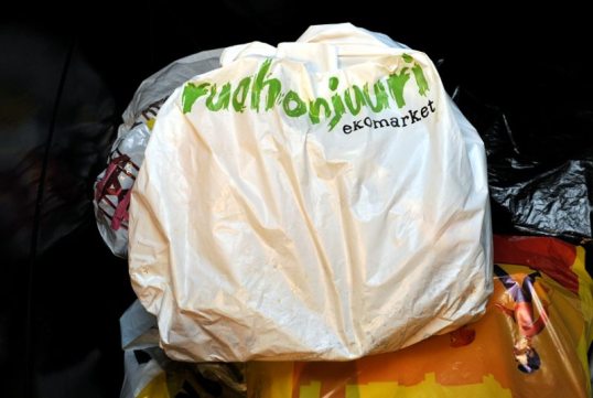 Ruohonjuuren valkoinen muovikassi sekajäteastiassa muiden muovikassien päällä.