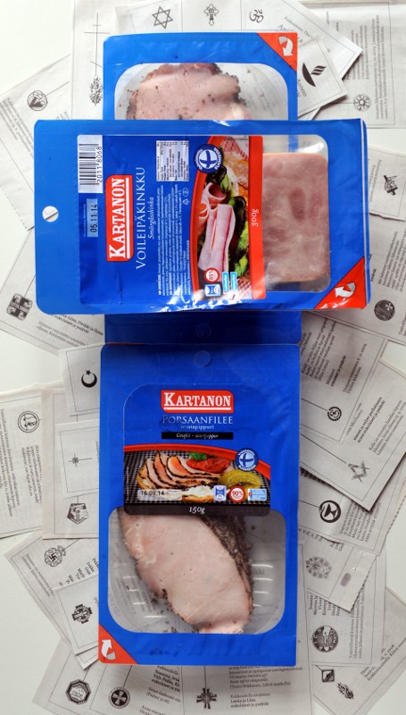 Kolme leikkelepakkausta ristin muotoon aseteltuna lehdestä leikattujen kuolinilmoitusten päällä.