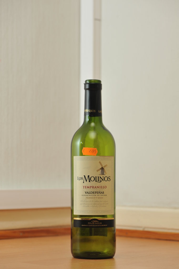 Tyhjä Los Molinos -punaviinin vihreä 0,75 litran lasipullo puunvärisellä lattialla.