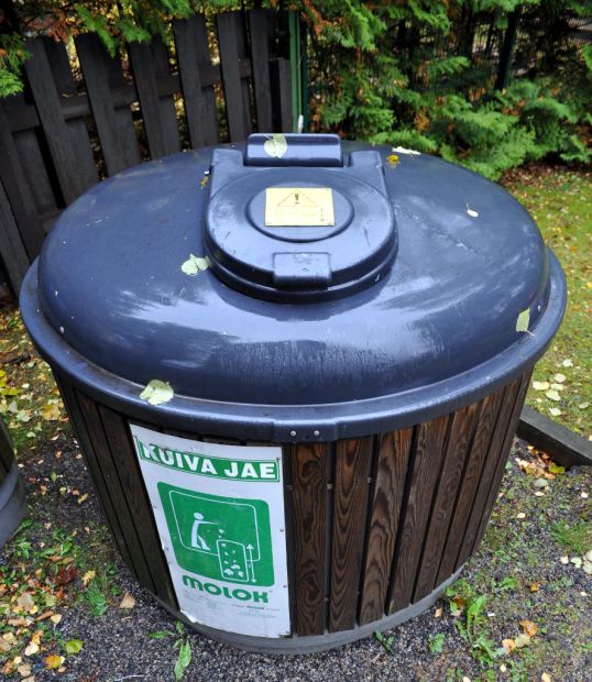 Pyöreä maahan upotettu jätesäiliö, jonka päällä on varoitus 2,7 metrin syvyydestä ja kyljessä lukee ”kuiva jae”.