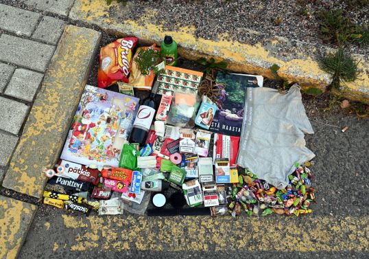 Kadulta löytyneitä tavaroita keltaiseksi maalattujen kadun ja reunakiveyksen rajaamalla alueella.