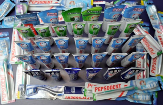 33 hammastahnaputkiloa pystyssä hammasharjapakkausten ympäröiminä.