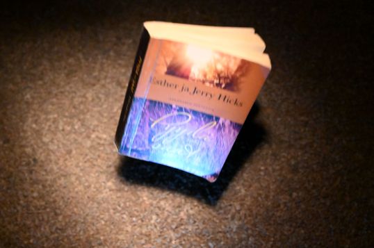 Pyydä, niin saat -kirja putoamassa sepelin päälle.