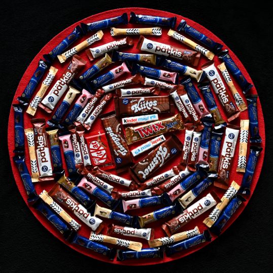 Ympyrän muotoisessa asetelmassa 67 suklaapatukkaa ja 11 lakritsipatukkaa.