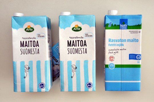 Kolme maitotölkkiä, joiden takana neljännessä maitotölkissä näkyy lehmän kuva.