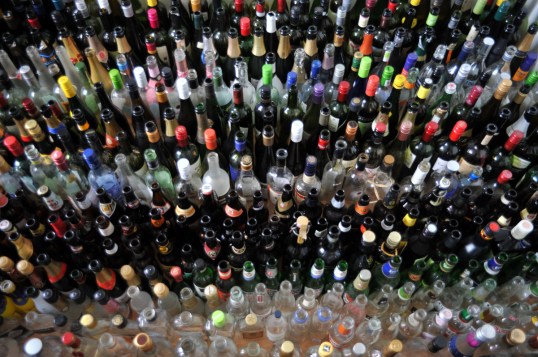 Suuri määrä erivärisiä ja -muotoisia lasipulloja ylhäältä päin kuvattuna.