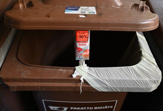 Mansikkakerma, jossa 30 prosentin alennuslappu, pakatun biojätteen astian kannen alla.